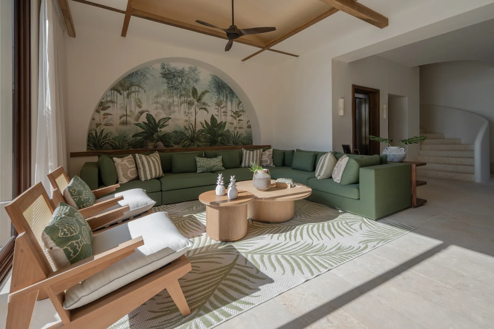 The green living room at Casa Ceiba under an arched hand-painted mural
