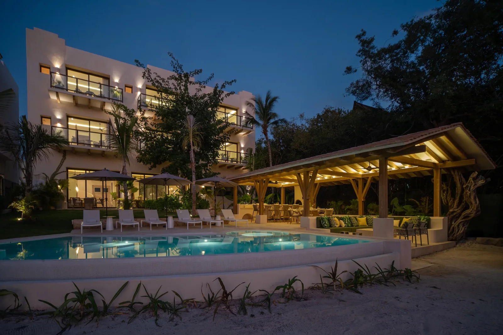 Casa Ceiba at night: the lit pool, the palapa and the house