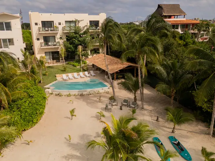 Casa Ceiba from the air: the palapa, the curved pool and the beach on Isla Mujeres
