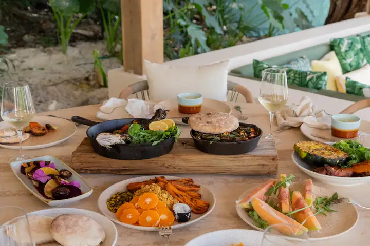 A lunch spread of ceviche, salads, fruit and fresh bread laid out by the pool