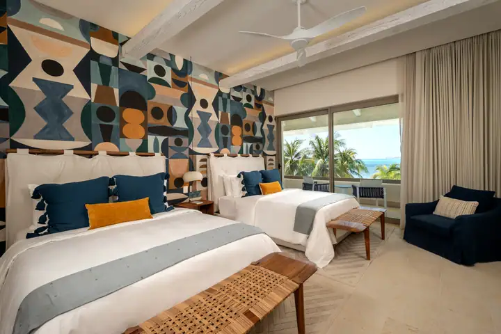 Double Room 5 at Casa Azul with a geometric mural behind two queen beds