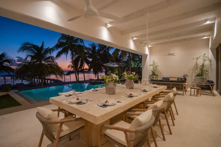 The long dining table at Casa Azul facing the pool at dusk