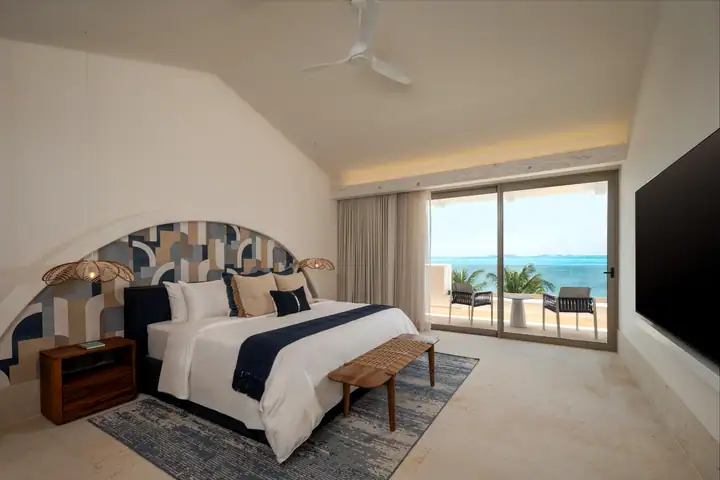 Master Suite 1 at Casa Azul: a king bed against a geometric mural, the sea outside