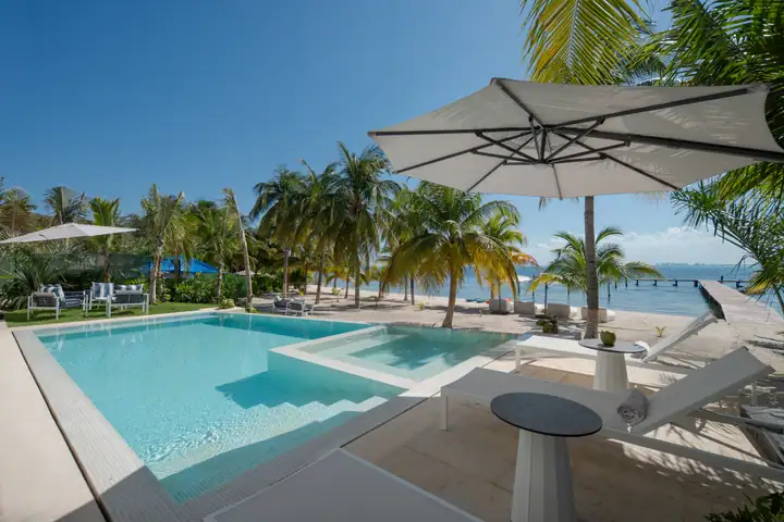 The Casa Azul pool under a white umbrella, the beach a few steps away