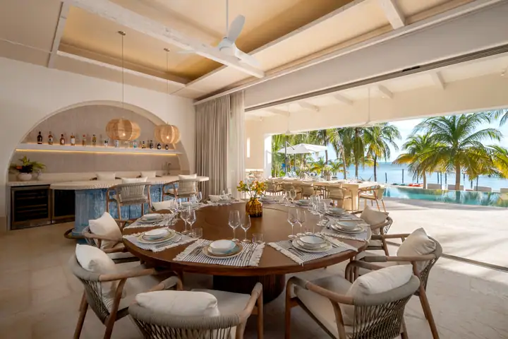 The round dining table at Casa Azul set for dinner, the sea through the open wall