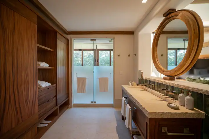 A walnut vanity and walk-in shower in a Casa Ceiba bathroom