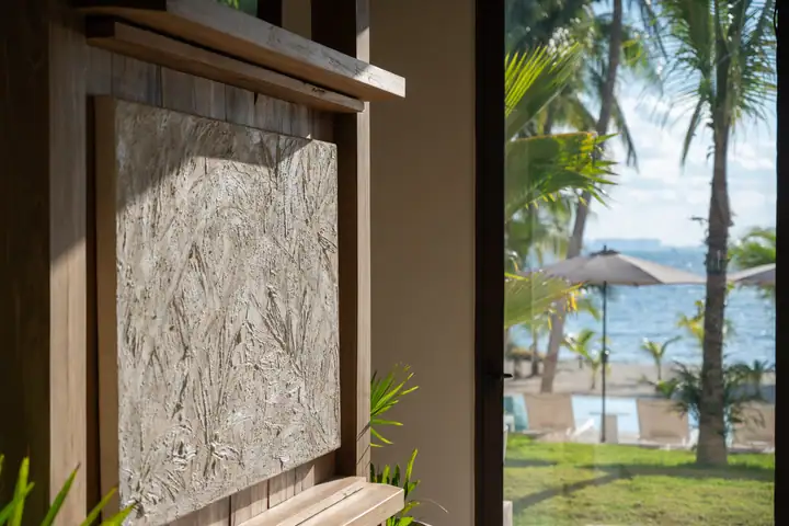 A carved fibre panel by the garden doors at Casa Ceiba, the beach behind