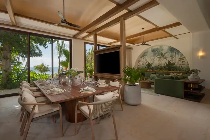 The open dining room and lounge at Casa Ceiba under timber beams