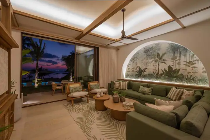 The Casa Ceiba lounge at sunset, the glass wall open to the garden