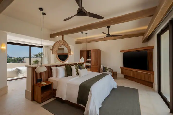 Master Suite 1 at Casa Ceiba: a king bed under timber beams with a sea-view balcony