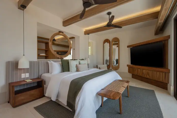 Master Suite 1 at Casa Ceiba with its round rattan mirror and king bed