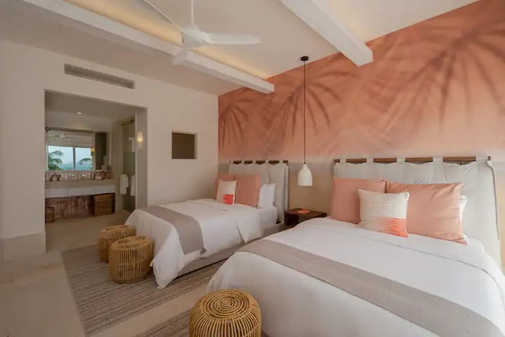 Double Room 5 at Casa Coral with a palm-leaf mural and two queen beds
