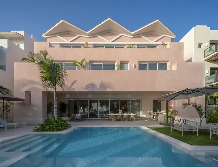 The sawtooth roofline and terraces of Casa Coral above the pool