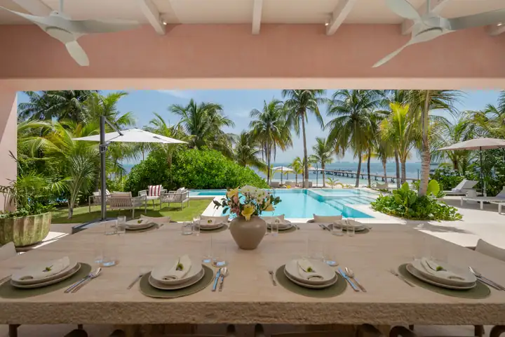 A long table set on the Casa Coral terrace looking over the pool to the beach