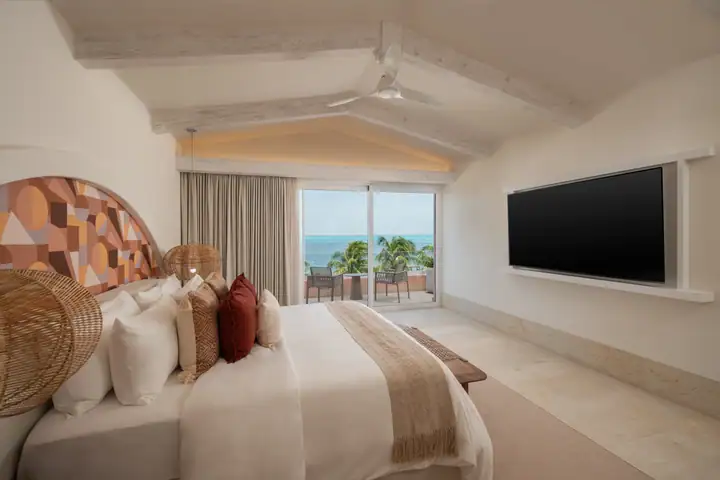 Master Suite 1 at Casa Coral: a king bed with a carved headboard and a sea view