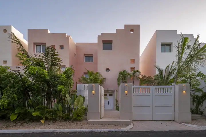 The street entrance of Casa Coral, pink walls and tropical planting