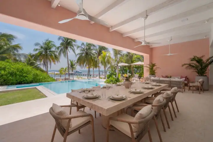 The terrace dining table at Casa Coral set for twelve, the pool and the sea beyond